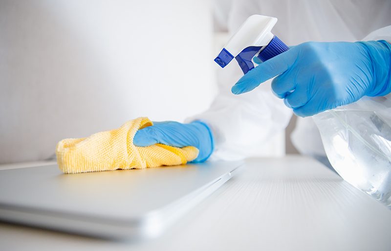 Cleaning service disinfects office, antiseptic processing of computer from coronavirus and germs.